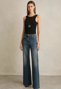 Musthave musta ilma varrukatega tops, mis on kokku sobitatud avarate siniste teksadega, millel on keskmise kõrgusega talje ja kerge pleekimine. Kuldne kaelakee ja käevõru kui aksessuaarid.