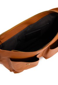 Sac en cuir marron avec fermeture éclair, présentant une poche intérieure et deux poches extérieures. Surface texturée avec des accents en métal doré.