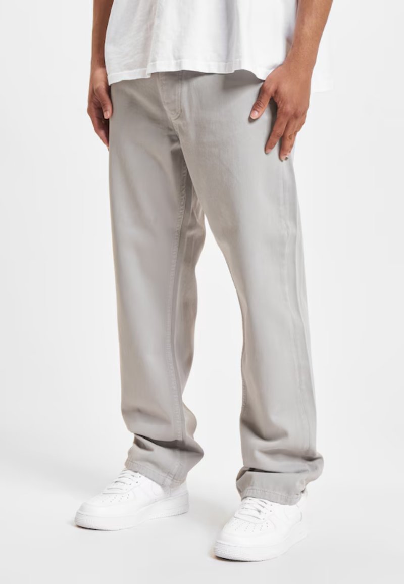 Light grey straight-leg pants made of denim, featuring a smooth texture and side pockets, paired with white sneakers.