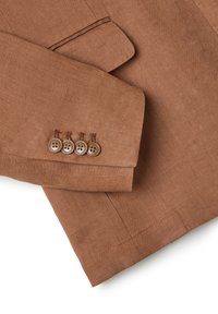 Manica di un blazer in lino marrone con colletto a revers, dotato di quattro bottoni rotondi marroni e dettagli di cucitura visibili.