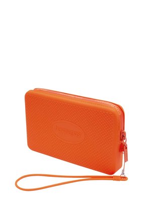 Pochette rectangulaire zippée orange vif avec surface texturée, bracelet et logo en relief "havaianas" sur le devant.