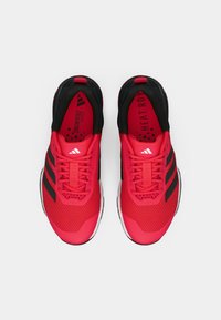 Red athletic shoes with black accents, mesh upper, and white sole. Features three black stripes and textured laces. Lightweight design.