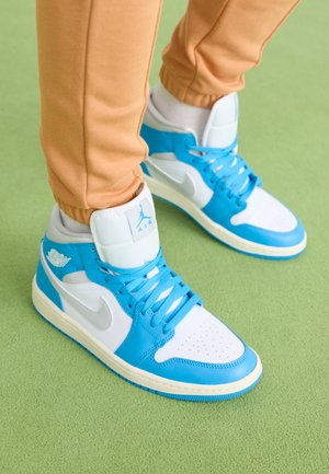 Pantofi sport înaltă, albaștri și albi, confecționați din piele netedă și materiale din plasă. Prezintă un vârf perforat, accente strălucitoare de albastru și detalii cu logo.