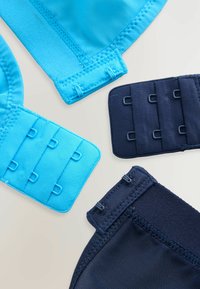 Twee beha haken in blauwe en marine stoffen, met een gladde textuur en meerdere haak- en oogsluitingen voor een veilige bevestiging.