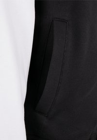 Zwart-witte hoodie met een gladde textuur, een kangoeroezak en contrasterende kleuren op de mouwen en het lichaam.