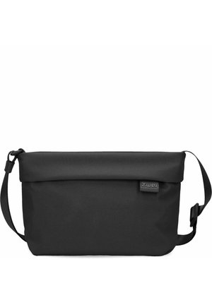 Bolso negro ajustable de bandolera con cierre enrollable y pequeña etiqueta de tela de la marca en el lado derecho del frente.