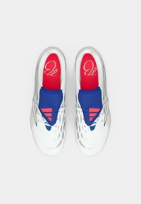 Άσπρα αθλητικά παπούτσια με μπλε και κόκκινες λεπτομέρειες, με σχέδιο στην επάνω επιφάνεια, ελαστικό κάλυμμα κορδονιών και λογότυπο στην εσωτερική σόλα.