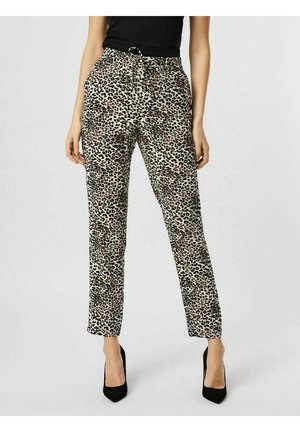 Kvinde iført leopardprint bukser med høj talje og sort bælte, kombineret med sorte spidse hæle og en sort ærmeløs top.