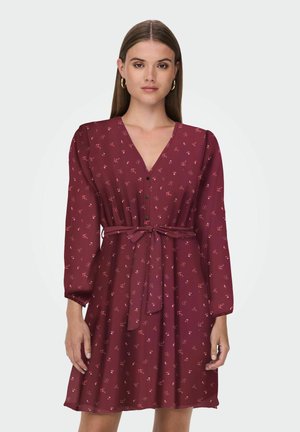 Bordeaux jurk met V-hals, lange mouwen, een strik taille en kleine bloemmotieven; gemaakt van een lichtgewicht, ademende stof.