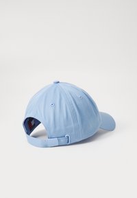 Lysblå baseballkasket med en buet skygge, lavet af tekstureret stof, med ventilationshuller og en justerbar rem bagpå.