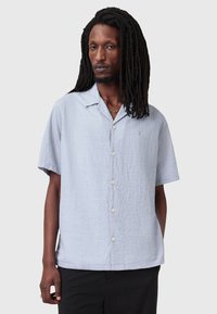 Camicia azzurra a maniche corte realizzata in tessuto texture, con chiusura a bottoni, colletto alla francese e una vestibilità comoda.