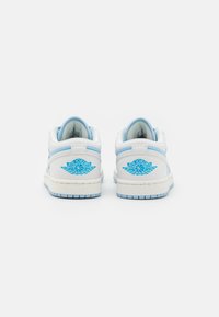 Sneakers low-top in pelle bianca con accenti azzurri, dotati di un logo blu "AIR JORDAN" sul tallone e di una suola in gomma testurizzata.