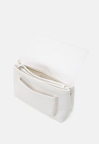 Vit läderhandväska med texturerad yta, utrustad med ett blixtlåsförsett huvudfack och en framficka utan stängning. Öppet utförande visar insidan.