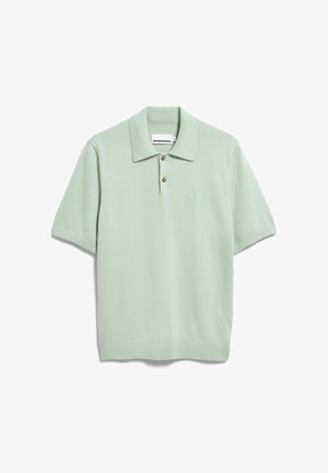 Polo à manches courtes vert clair avec deux boutons marron, col tricoté, et petit logo brodé sur le côté gauche de la poitrine.