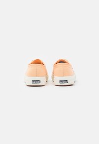 Oranžové plátěné slip-on boty s texturovaným povrchem, bílou gumovou podrážkou a černým logem „SUPERGA“ na patě.