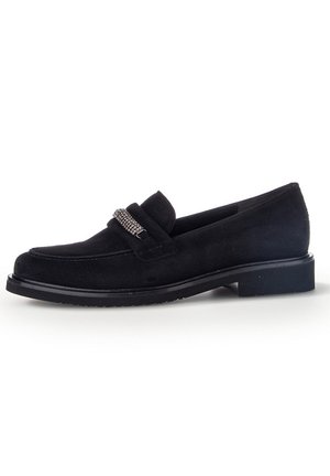 Sorte ruskinds loafers med rund tå, der har en dekorativ sølvfarvet rem på vristen og en lav sort gummisål.