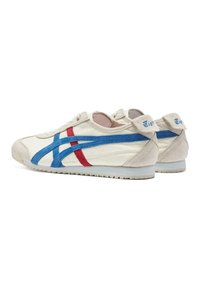 Sneaker con parte superiore in pelle crema, strisce in suede blu e rosso, lacci bianchi e suola in gomma. Presenta un logo sul tallone.