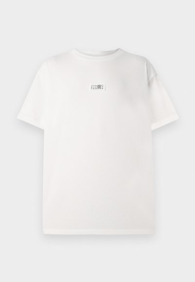 Bela bombažna majica s kratkimi rokavi, ki ima v sredini majhno natisnjeno oznako. Ohlapen kroj in gladka tekstura.