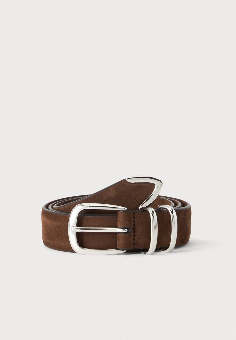 Ceinture en cuir marron roulée avec une boucle métallique argentée brillante et deux passants sur un fond clair uni.