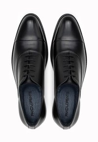 Czarne skórzane eleganckie buty na nogach z gładkim, zaokrąglonym noskiem, sznurowanym przodem oraz gładką teksturą. Wnętrze wykończone kontrastującą ciemnoniebieską podszewką.