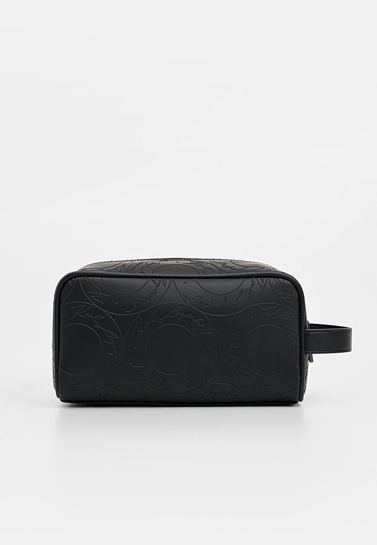 Borsa cosmetica nera con motivi circolari in rilievo e scritte, forma rettangolare, apertura con cerniera e manico laterale per un facile trasporto.