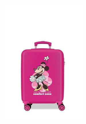 Maleta rosa brillante con Minnie Mouse de caricatura, sombrero de flores, falda de lunares, zapatos amarillos y texto "Salta fuera de tu zona de confort." Cuatro ruedas visibles.
