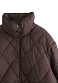 Brun quiltet jakke med høj krave og trykknapper langs forsiden, mod en hvid baggrund.