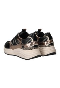 Baskets chunky avec un mesh noir, des accents métalliques bronze, des détails à motifs, des lacets noir et blanc, et des semelles blanches épaisses, vues de l'angle arrière.