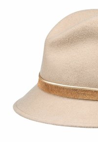 Beige Woll-Fedora-Hut mit breiter Krempe, ausgestattet mit einem braunen Wildlederband und einem goldenen Akzent entlang des Randes des Bandes.
