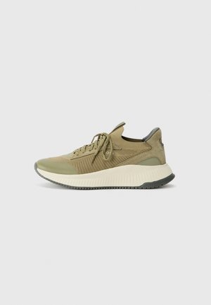 Lace-up sneaker in light olive green fabric with textured accents, reinforced toe, and a thick, contrasting white midsole. Rubber outsole for grip.