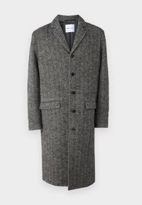 Siv plašč iz volne v herringbone vzorcu s spodnjim ovratnikom, šestimi gumbi, žeparenimi žepi in dolžino do kolen. Gladka tekstura in prilagojen kroj.
