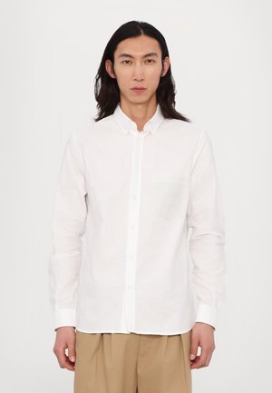 White long-sleeve shirt made of lightweight fabric, featuring a button-up front, a left chest pocket, and a relaxed fit.