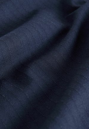 Námornícky textúrovaný materiál s jemnými vertikálnymi pruhmi, vyrobený z mäkkého materiálu, s hladkým padaním a rovnomernou farbou.