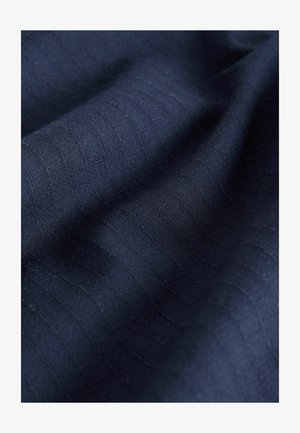 Námornícky textúrovaný materiál s jemnými vertikálnymi pruhmi, vyrobený z mäkkého materiálu, s hladkým padaním a rovnomernou farbou.