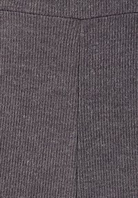 Tejido gris acanalado con una textura sutil. La tela presenta líneas verticales y un tono uniforme, adecuada para diversos prendas de vestir.