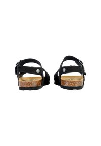 Sandali in suede nero con più cinturini, fibbia regolabile e suola in sughero. Presentano un tacco arrotondato e una suola in gomma per una migliore aderenza.