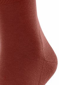 Czerwona skarpetka do kostki wykonana z gładkiego, elastycznego materiału z prążkowanym ściągaczem. Posiada zwężony kształt oraz bezszwowy czubek dla większego komfortu.