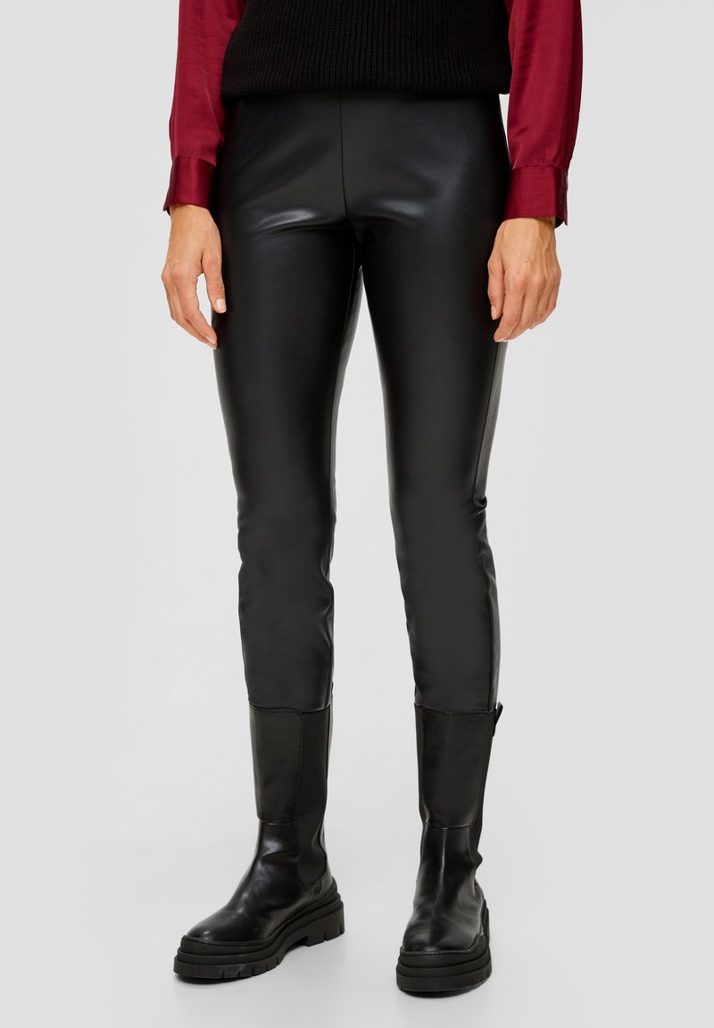 Zwarte faux leren broek met een slim fit, voorzien van een gladde textuur en gecombineerd met zwarte enkellaarzen. De top is een bordeauxrood overhemd en een gebreide vest.