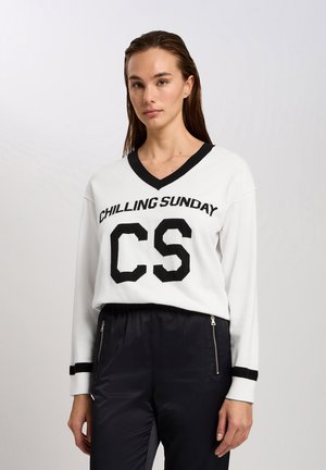 Weißes V-Ausschnitt-Sweatshirt mit schwarzem Text "CHILLING SUNDAY" und "CS"-Logo. Lange Ärmel mit schwarzen Akzenten an den Bündchen. Weiche Stricktextur.