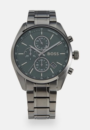 Montre chronographe en acier inoxydable avec un cadran vert foncé, trois sous-cadrans, des accents argentés et un affichage de la date à 6 heures.