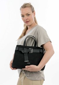 Sac à main noir au design structuré, fabriqué en suède et en cuir. Doté d'une bandoulière texturée et d'accents en matériel argenté. Les poignées sont rondes.