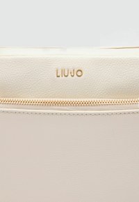 Beige Leder-Clutch mit strukturiertem Finish, ausgestattet mit einem goldfarbenen Reißverschluss und dem auf der Vorderseite geprägten Markenlogo "LIU-JO."