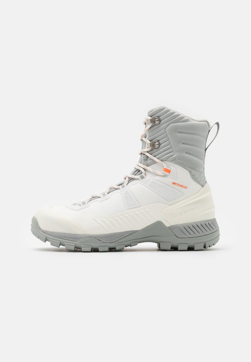 Botas de senderismo blancas de corte medio, con un cuello texturizado gris, puntera reforzada y suela de goma gris con tacos multidireccionales.