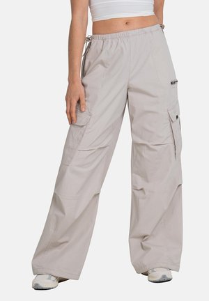 Light beige cargo pants with a relaxed fit, elastic waistband, multiple pockets, and a smooth, textured fabric.