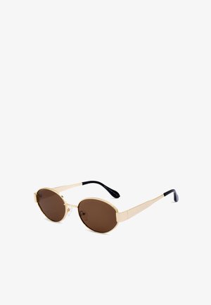 Złote okulary przeciwsłoneczne z owalnymi brązowymi soczewkami i cienkimi, wydłużonymi oprawkami. Czarne końcówki na zausznikach. Brak widocznych wzorów lub akcentów.