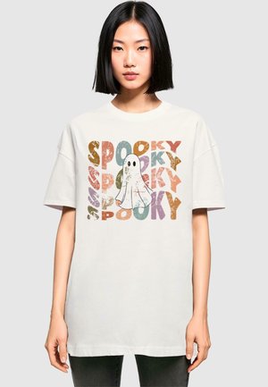 Hvid oversized t-shirt med et legesygt spøgelse design, hvor der står "SPOOKY" i flerfarvede, slidte bogstaver i forskellige størrelser.