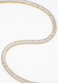 Gold-tone necklace featuring rectangular clear crystals set in a zigzag pattern, creating a flexible, shimmering design.