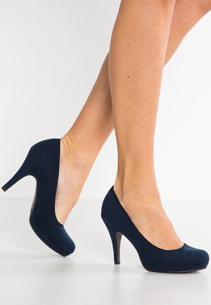 Navy blue suede high-heeled pumps with a rounded toe and a smooth, textured finish. The heel is slender and glossy, contrasting the shoe's material.