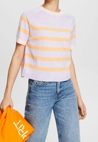 Gestreifter Stricktop in Flieder und Pfirsich, kurze Ärmel, runder Halsausschnitt, cropped Design. Kombiniert mit hellblauen Jeans und einem orangefarbenen Sweatshirt.