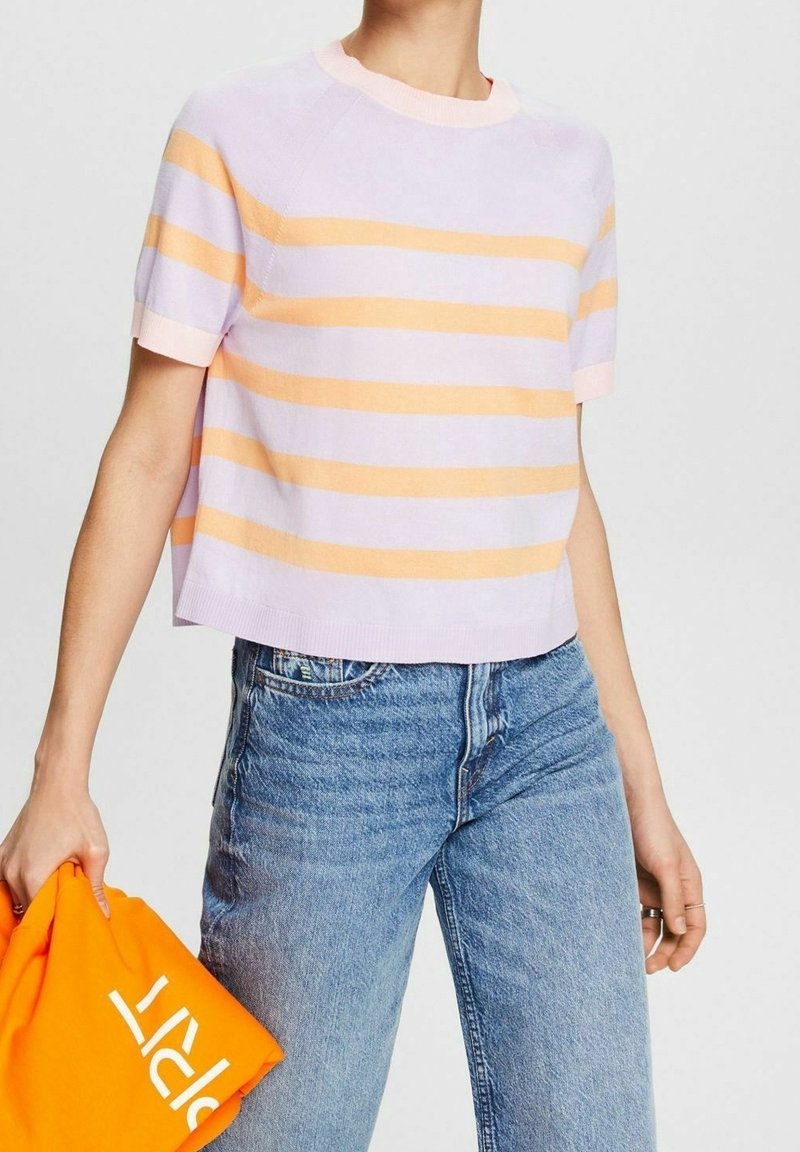 Gestreifter Stricktop in Flieder und Pfirsich, kurze Ärmel, runder Halsausschnitt, cropped Design. Kombiniert mit hellblauen Jeans und einem orangefarbenen Sweatshirt.